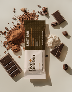 Five Plus Protein Cafe Mocha Latte with Cacao Nibs + Caffeine with chocolate and coffee beans next to it on a table