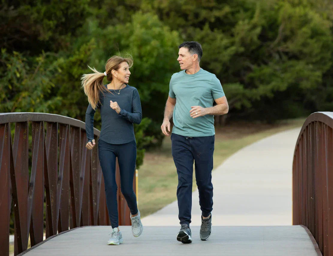 Couple running across a bridge